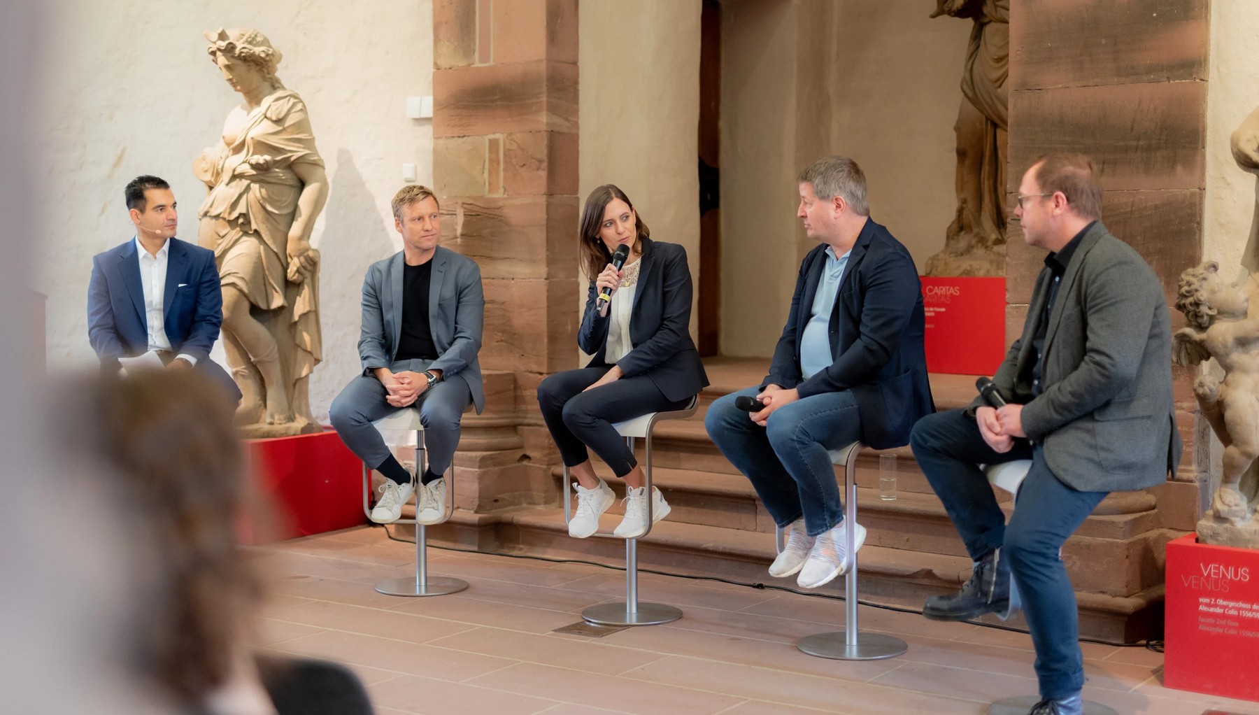 Paneldiskussion mit mehreren Gästen in den historischen Räumen des Schlosses